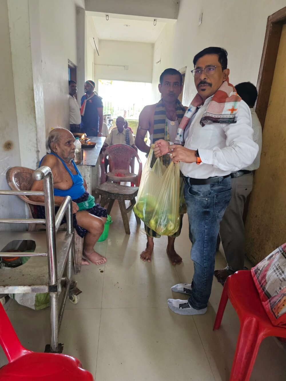 A Brains Iconic Charitable Trust volunteer delivering essentials to an elderly resident at a care home.
